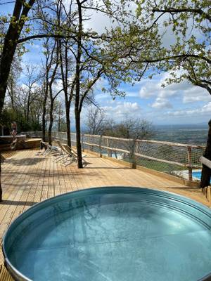 Whirlbadewanne auf einer Holzterrasse im Campsite Barco Reale mit Blick auf Bäume und einen bewölkten Himmel.