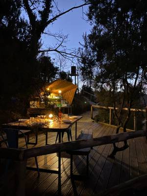 Abendessen im Campingplatz Barco Reale mit Holzdeck und Hütte im Hintergrund.