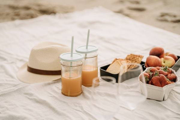Picknick am Strand mit Obst und Getränken