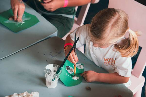 Niño pintando en el camping Union Lido Mare, concentrándose en un proyecto.