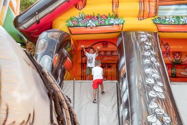 Dos niños pequeños saltan en una casa inflable en el camping Union Lido Mare.
