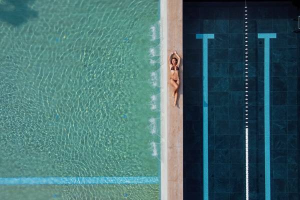 Mujer acostada en el borde de una piscina en el camping Union Lido Mare.