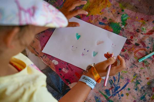 Niño coloreando un dibujo en una mesa en el camping Union Lido Mare.