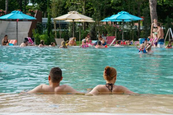 Escena de piscina del camping Union Lido Mare con muchas personas nadando.