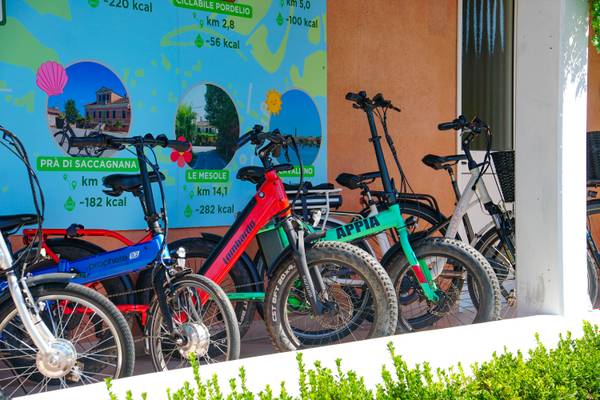 Varias bicicletas coloridas estacionadas fuera de un edificio con un mapa en el fondo.