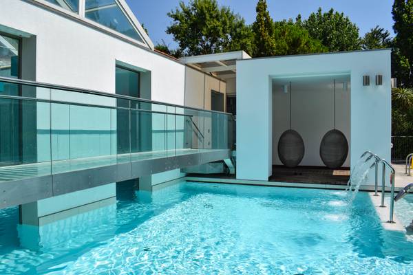 Área de piscina en el camping Union Lido Mare con un puente de cristal.