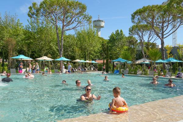 Piscina de camping con visitantes y sombrillas en un día soleado en Union Lido Mare