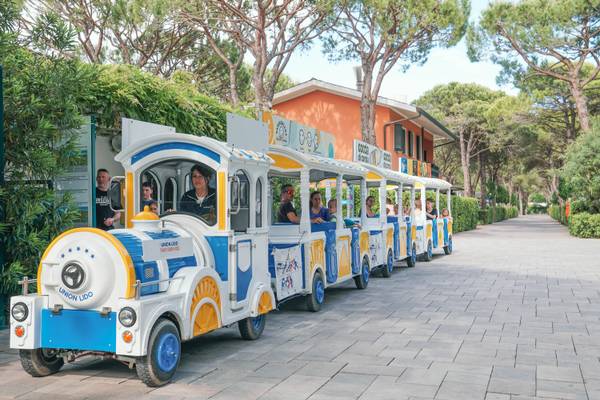 Un vehículo tipo tren en el camping Union Lido Mare con personas montando.