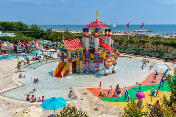 Vista aérea del parque acuático del camping Union Lido Mare con estructuras coloridas y personas nadando