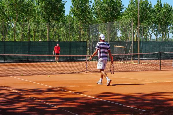 Jugadores de tenis en la cancha de tenis del camping Union Lido Mare.