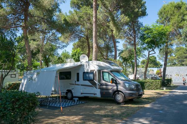 Camping-car stationné sur un camping sous un auvent