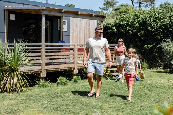 Familie, der går foran et hus i Camping Village L`Océan Breton