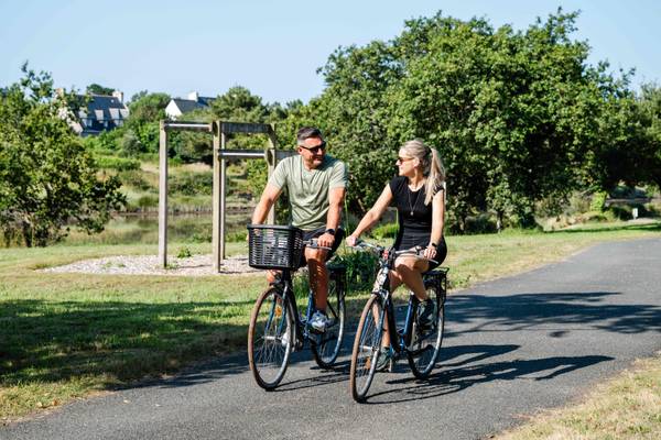 To personer cykler pa en sti i en camping