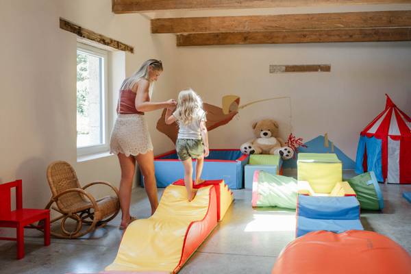 Une salle de jeux au Camping Village L`Océan Breton avec une glissade et des jouets.