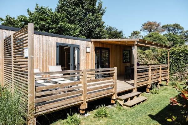 Maison de vacances au Camping Village L`Océan Breton avec terrasse en bois et chaises