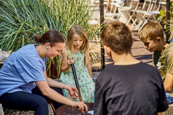 An adult and children participate in an activity at the Henne Strand Resort campsite.