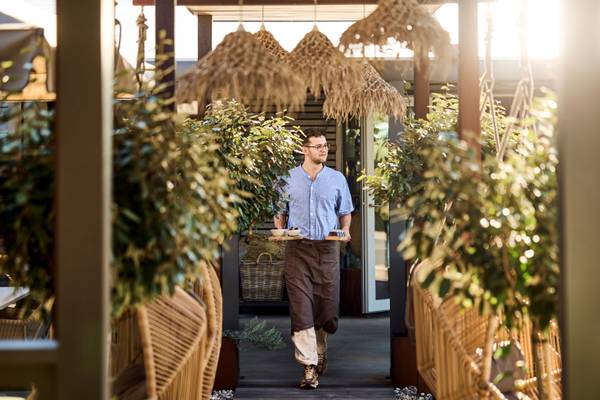 A waiter carrying food trays at Henne Strand Resort campsite