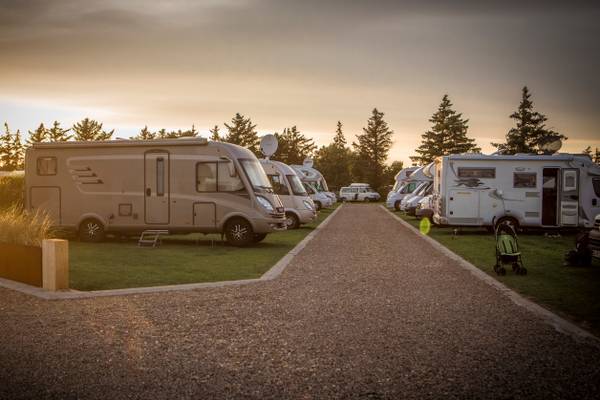 RVs parked at Henne Strand Resort campsite under a cloudy sky