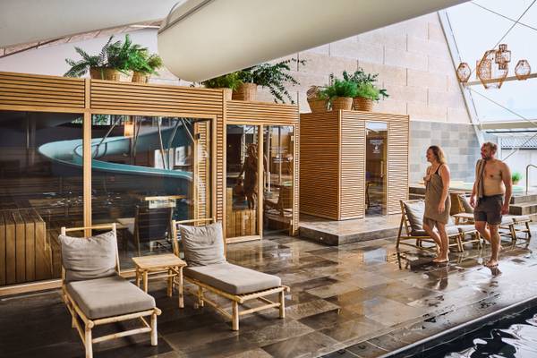 A lounge area at Henne Strand Resort with wooden furniture and a swimming pool.