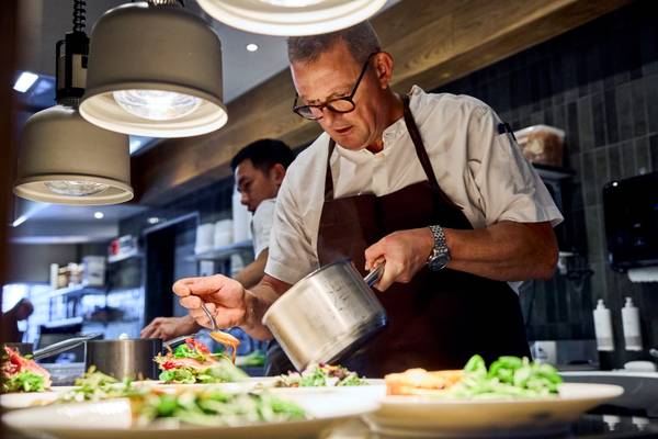 Chef pouring sauce on salad in a restaurant at Henne Strand Resort.