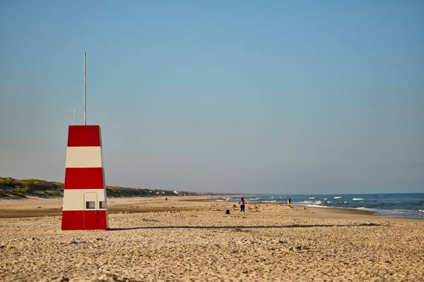 A red and white striped tower stands on the beach at Henne Strand Resort.