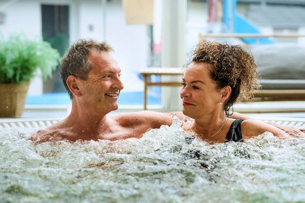 A couple at Henne Strand Resort relaxing in a hot tub