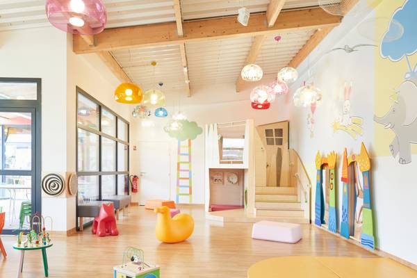 Sala de juegos para niños en Camping Les Mouettes con muebles coloridos y lámparas colgantes.