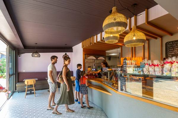 Una familia está en el mostrador del café dentro del Camping Les Mouettes.