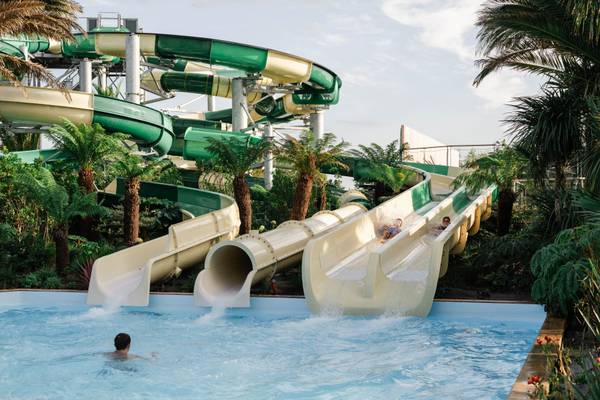 Tres grandes toboganes de agua en Camping Les Mouettes con personas deslizándose