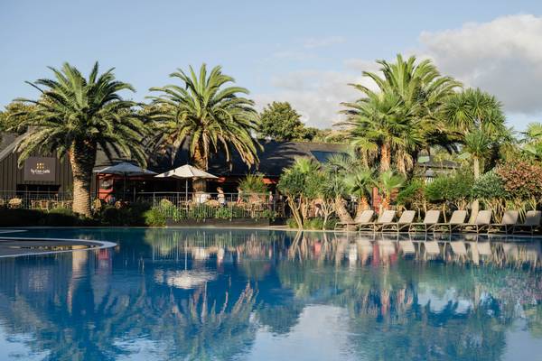 Piscina en Camping Les Mouettes con tumbonas y palmeras