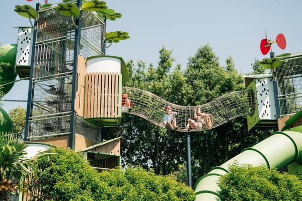 Zona de juegos de aventura en Camping Les Mouettes con niños en un puente de cuerda.