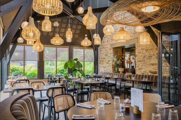 Interior del restaurante Camping Les Mouettes con mesas de madera, sillas y lámparas decorativas.