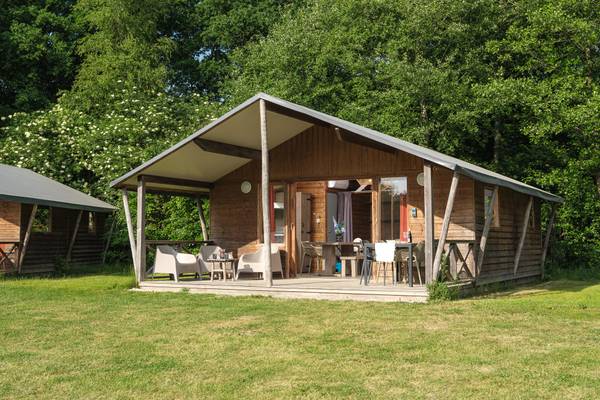 A cozy cabin with outdoor furniture at Camping De Paal