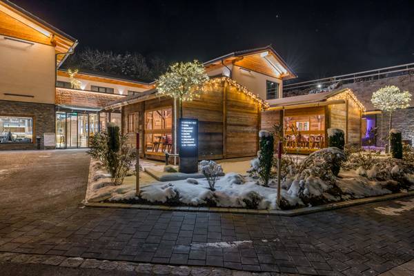 Vista nocturna del Camping Resort Bodenmais con carteles iluminados y suelo cubierto de nieve.