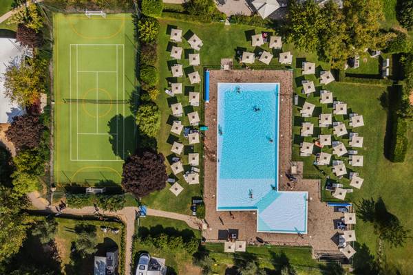 Luftfoto af Fornella Camping & Wellness Family Resort med swimmingpool og sportsplads.