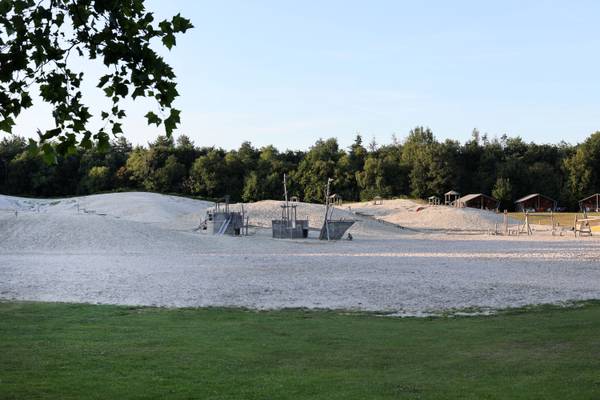 Sunset view of Camping De Paal with sand dunes and playground structures
