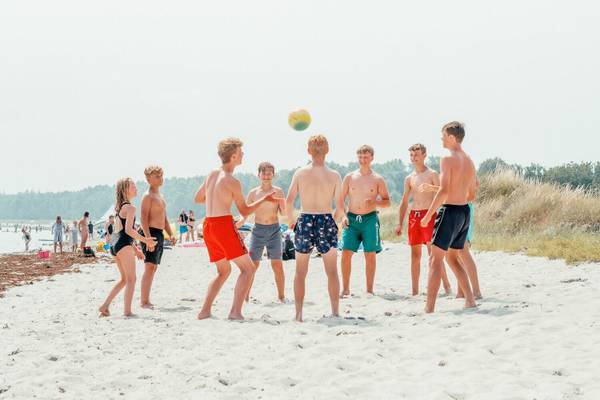 Grupo de jóvenes jugando voleibol en la playa del Feddet Strand Resort