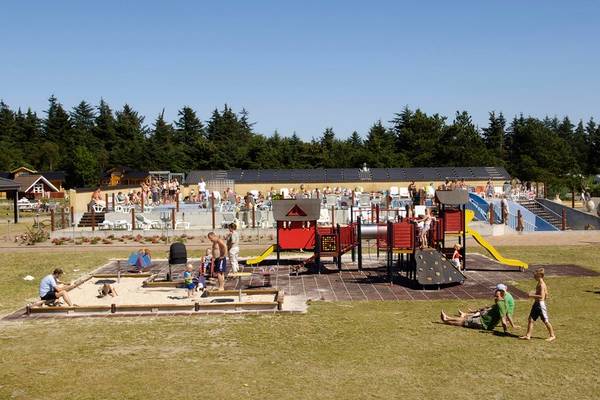Vista general del parque de juegos del Jambo Feriepark con niños jugando y adultos sentados.