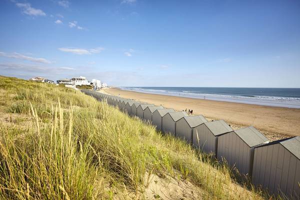 Vue de plage avec cabanes de plage et dunes au Camping Le Pin Parasol