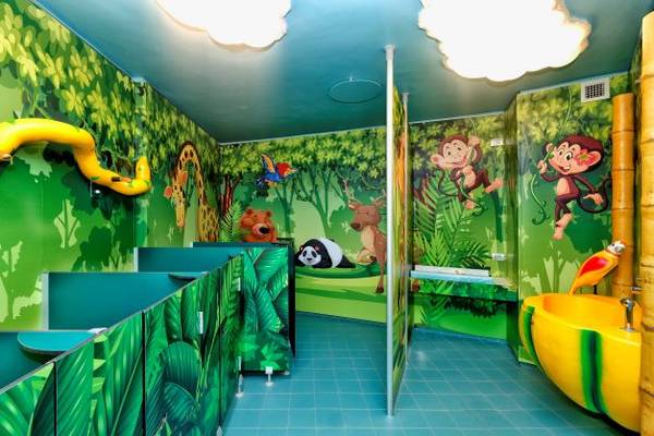 Børnetoilet på campingpladsen Piani di Clodia med jungle-tema vægmaleri og legesyg dekoration.
