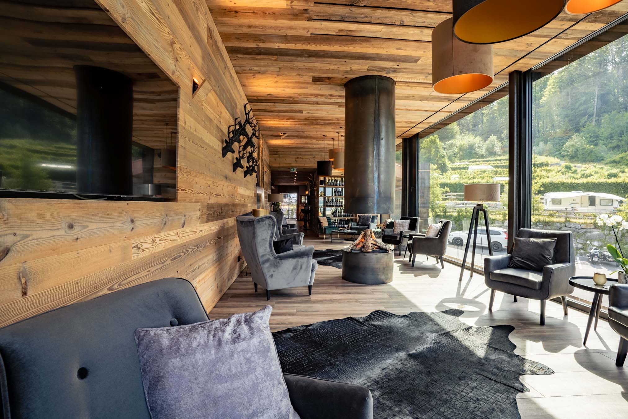 Vista interna del ristorante dell'Alpencamping Nenzing con pareti in legno e mobili moderni.