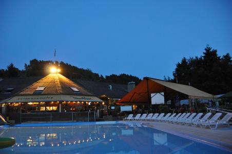Natlig udsigt af Europacamping Nommerlayens poolområde med liggestole og et bygning.