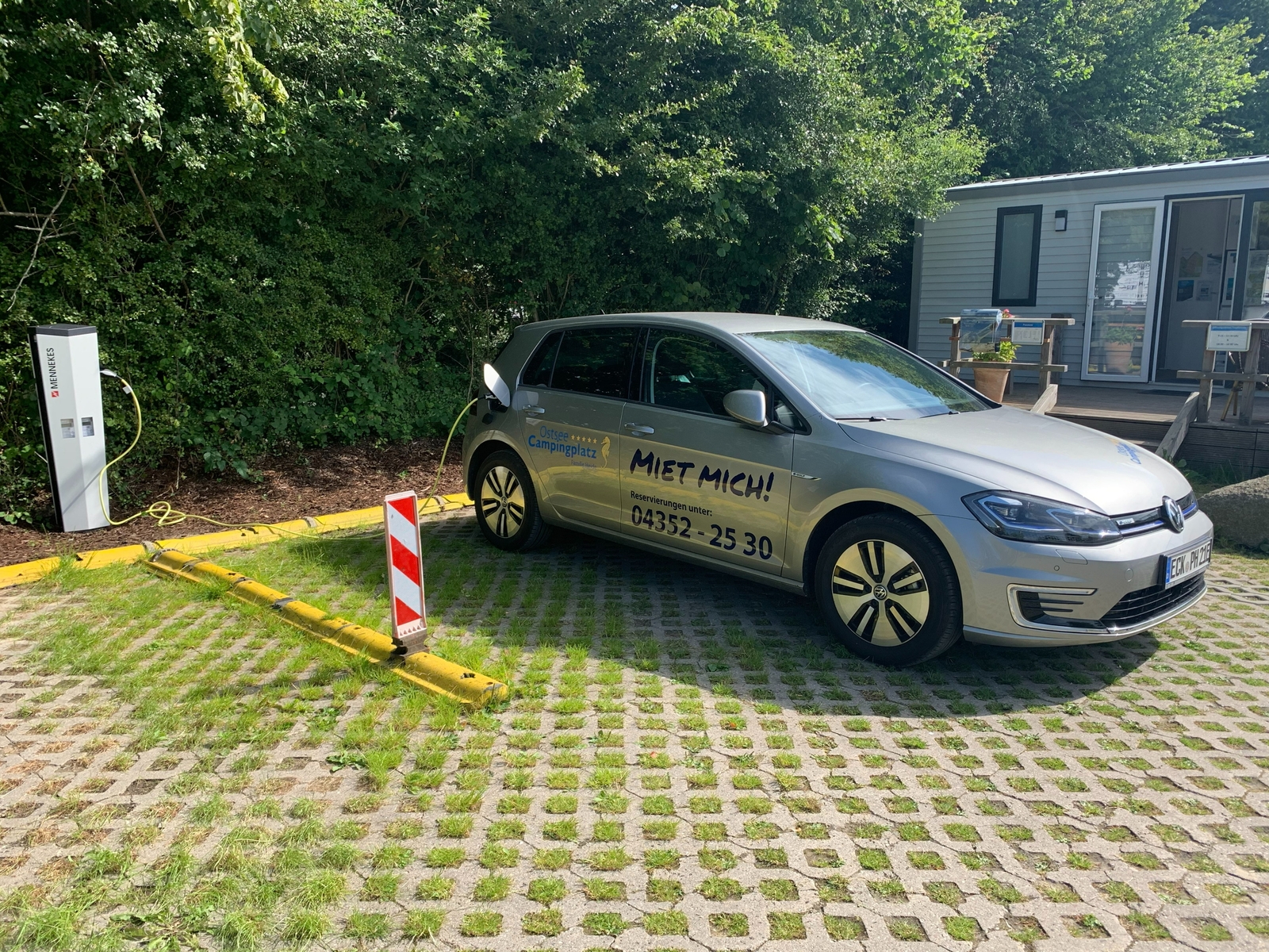 Elbil oplader på campingplads Ostseecamping Heide, parkeret på murstensgrund.