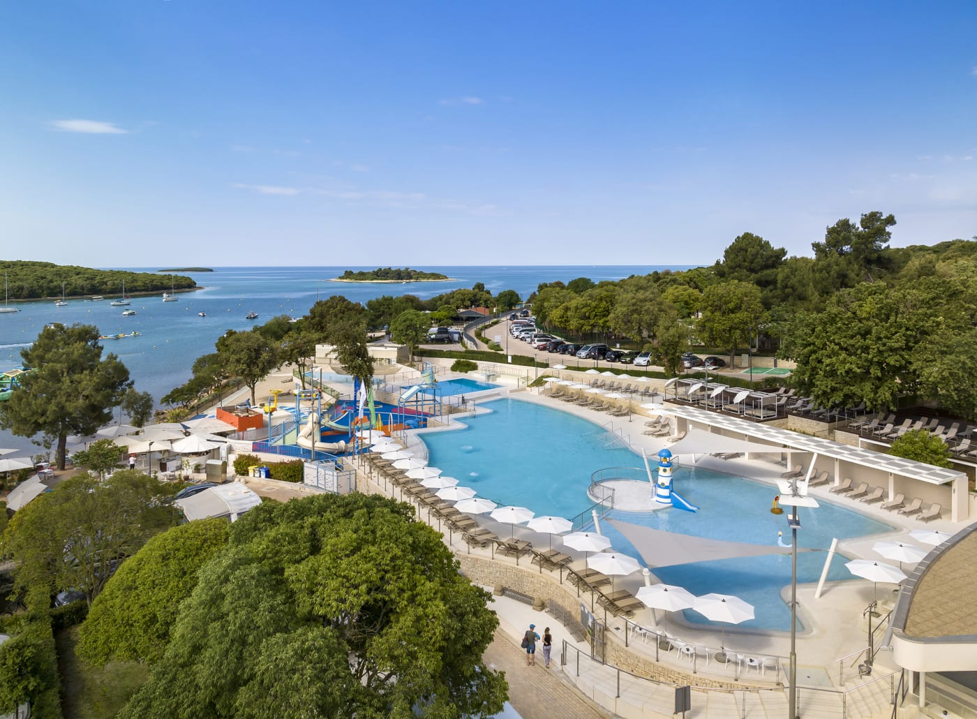 Aerial view of Camping Vestar with a large pool, water slides, and a sea view.
