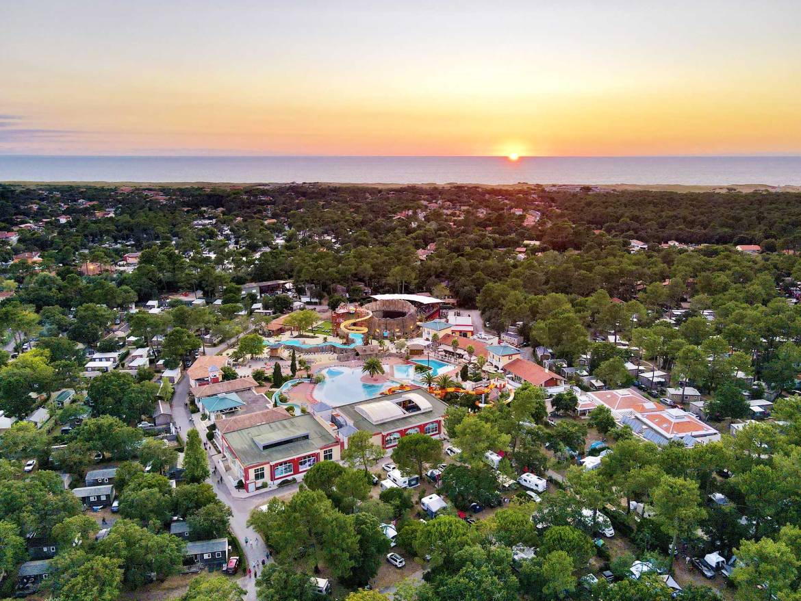 Vista aerea del Camping Village Sylvamar al tramonto con vista sull'oceano.