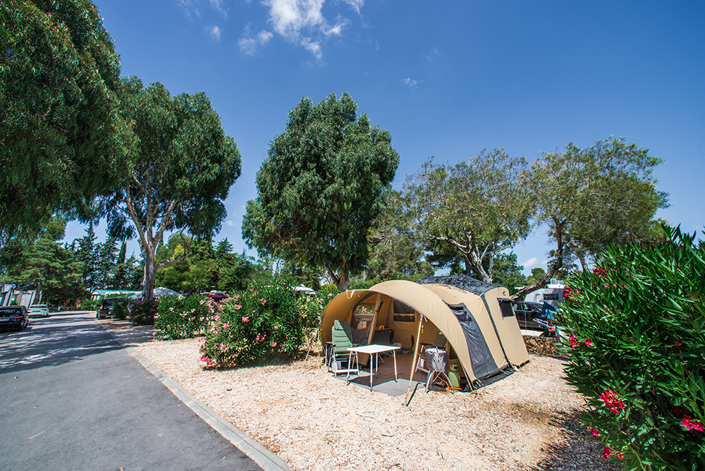 En telt opsat i Turiscampo Camping Club Algarve, omgivet af træer og buske.