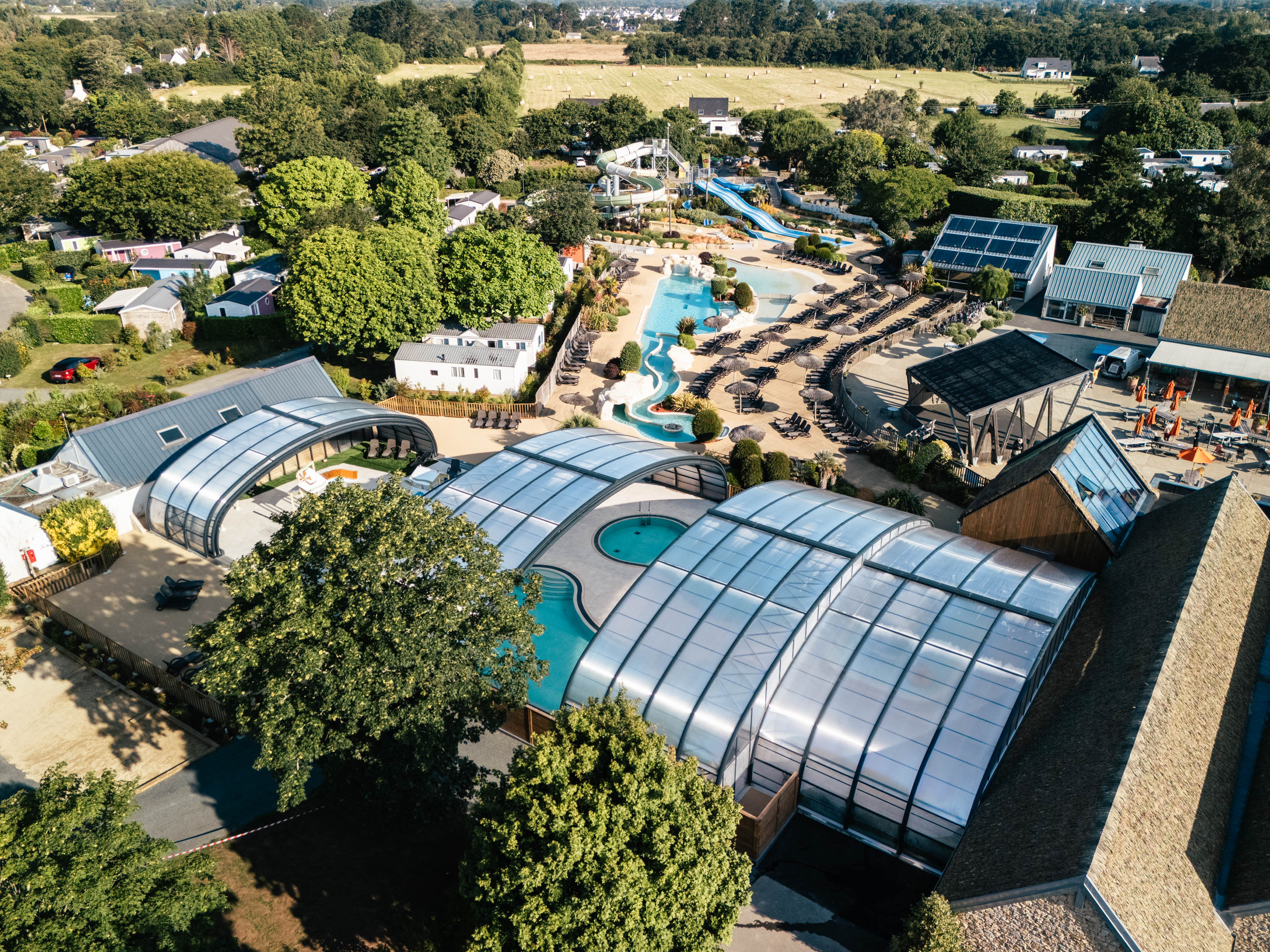 Vista aerea del Camping Village L`Océan Breton con piscine, scivoli e edifici.