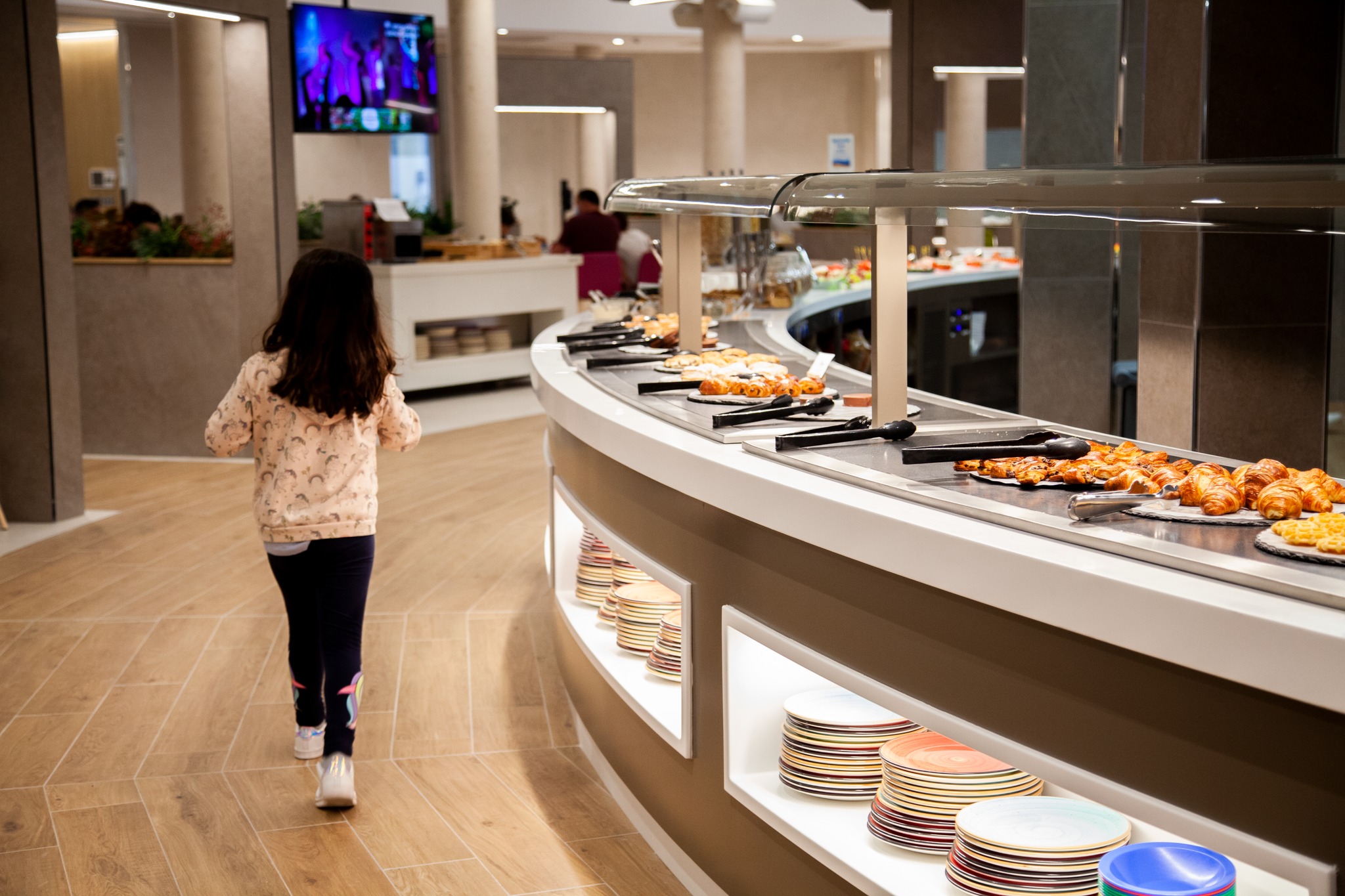 A girl at La Marina Camping & Resort restaurant walking past a buffet.