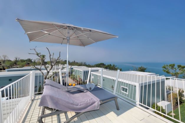 Balcony with sun loungers and umbrella overlooking the sea
