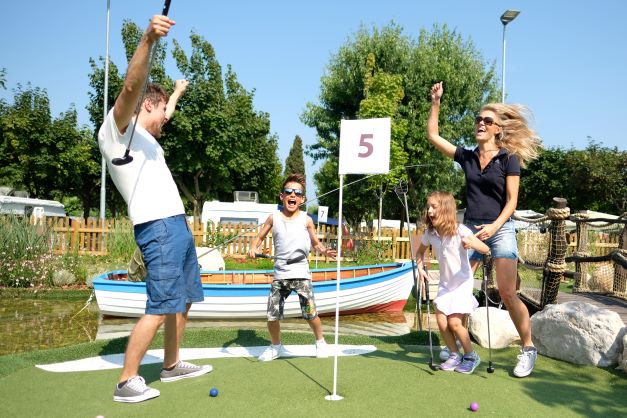 Family playing mini golf at the Piani di Clodia campsite